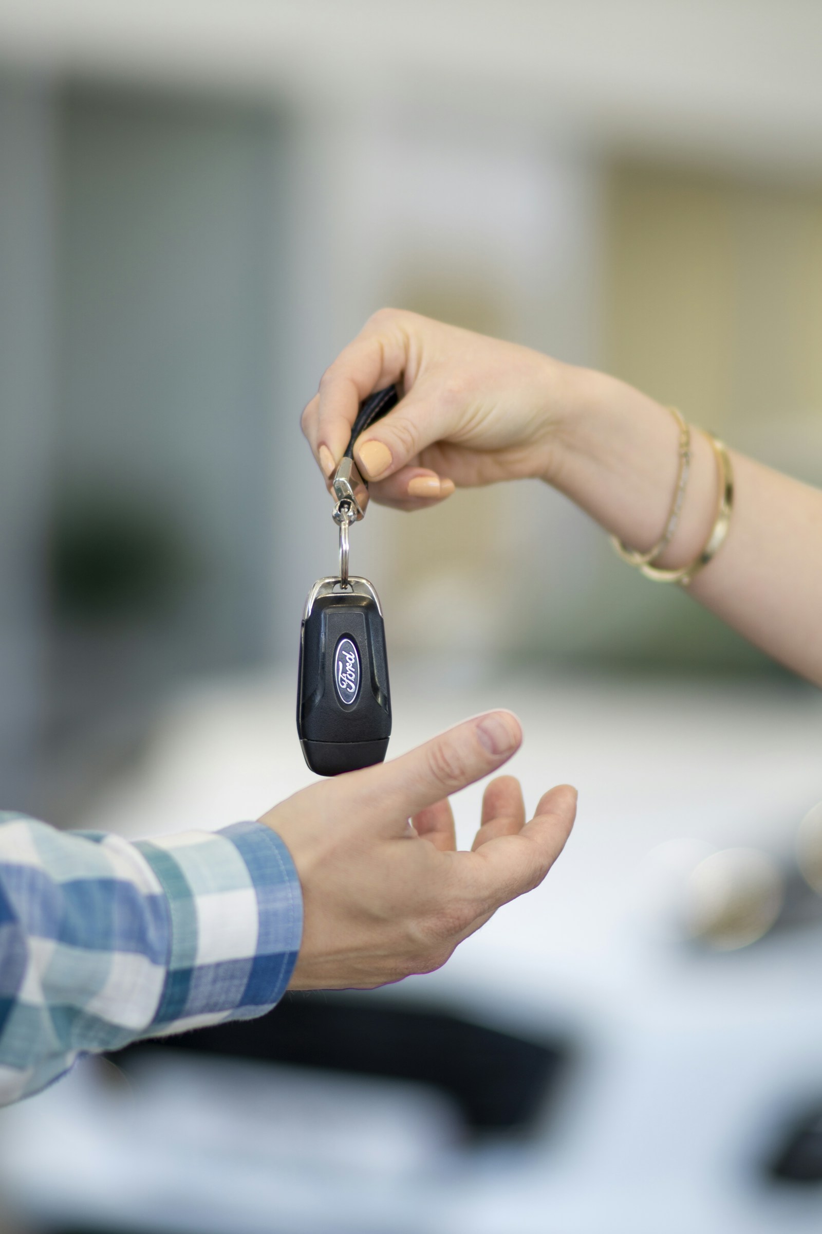 Autoschlüssel werden neben einem weißen Auto übergeben